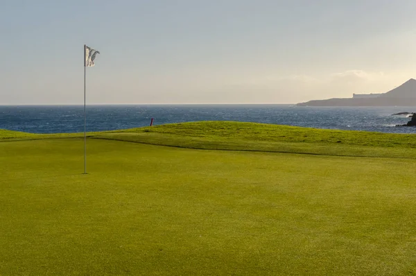 Green golf with flag and hole facing Atlantico ocean in Santa Cr — Stock Photo, Image