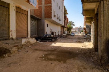 Mısır, Hurghada, çok aile evleri ve eski arabaları olan kirli sokaklar.