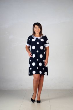 Gri bir arka plan üzerinde poz güzel genç kız