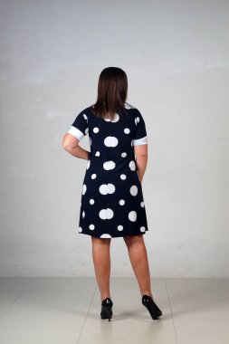 Gri bir arka plan üzerinde poz güzel genç kız