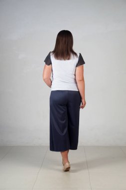 Gri bir arka plan üzerinde poz güzel genç kız