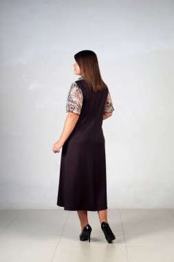 Gri bir arka plan üzerinde poz güzel genç kız