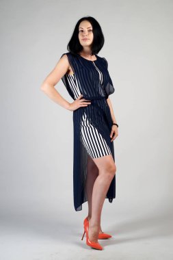 Gri bir arka plan üzerinde poz güzel genç kız