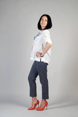 Gri bir arka plan üzerinde poz güzel genç kız