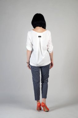 Gri bir arka plan üzerinde poz güzel genç kız