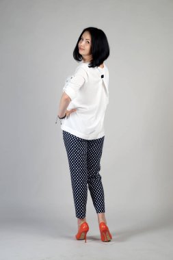 Gri bir arka plan üzerinde poz güzel genç kız