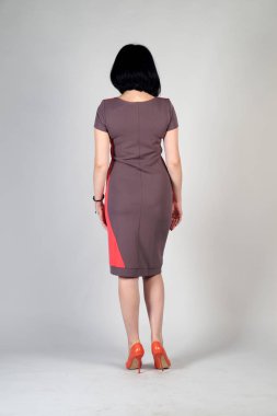 Gri bir arka plan üzerinde poz güzel genç kız