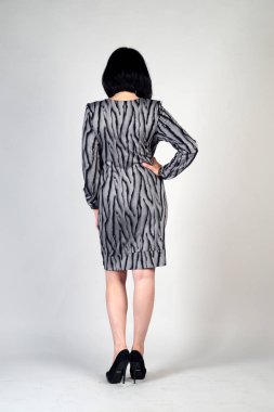 Gri bir arka plan üzerinde poz güzel genç kız