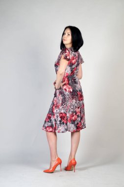 Gri bir arka plan üzerinde poz güzel genç kız