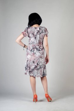 Gri bir arka plan üzerinde poz güzel genç kız