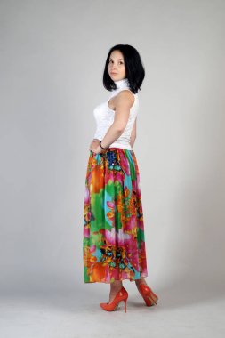 Gri bir arka plan üzerinde poz güzel genç kız