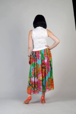 Gri bir arka plan üzerinde poz güzel genç kız