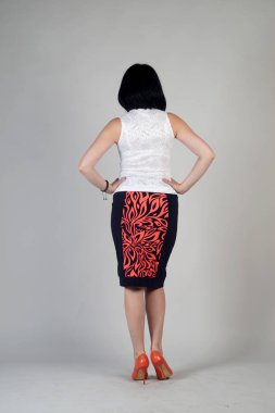 Gri bir arka plan üzerinde poz güzel genç kız