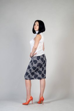 Gri bir arka plan üzerinde poz güzel genç kız