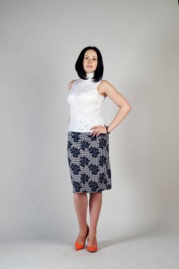 Gri bir arka plan üzerinde poz güzel genç kız