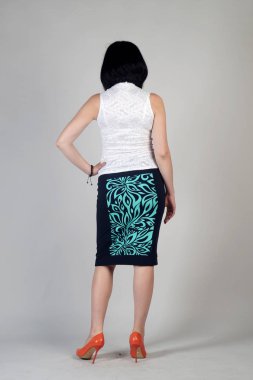 Gri bir arka plan üzerinde poz güzel genç kız