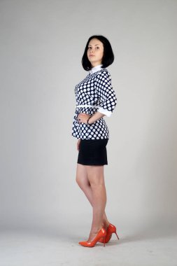 Gri bir arka plan üzerinde poz güzel genç kız