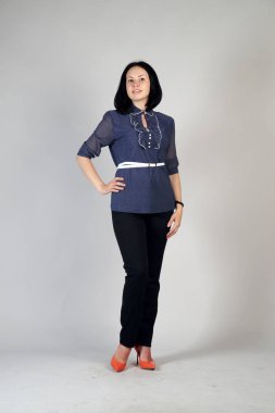 Gri bir arka plan üzerinde poz güzel genç kız