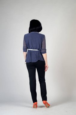 Gri bir arka plan üzerinde poz güzel genç kız