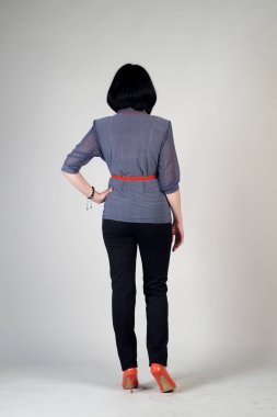 Gri bir arka plan üzerinde poz güzel genç kız