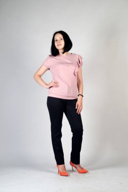 Gri bir arka plan üzerinde poz güzel genç kız