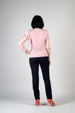 Gri bir arka plan üzerinde poz güzel genç kız