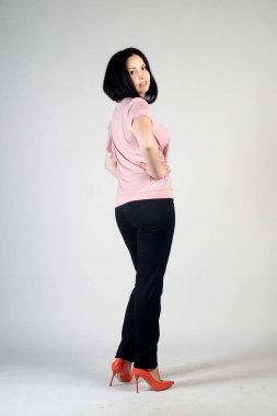 Gri bir arka plan üzerinde poz güzel genç kız