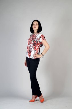 Gri bir arka plan üzerinde poz güzel genç kız