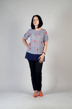 Gri bir arka plan üzerinde poz güzel genç kız