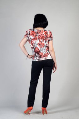 Gri bir arka plan üzerinde poz güzel genç kız