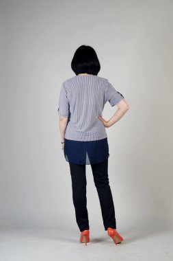 Gri bir arka plan üzerinde poz güzel genç kız