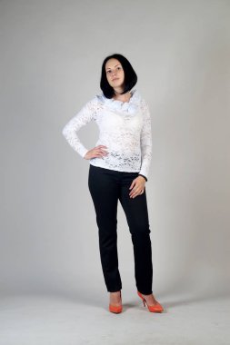 Gri bir arka plan üzerinde poz güzel genç kız