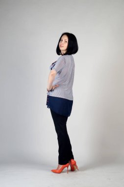 Gri bir arka plan üzerinde poz güzel genç kız