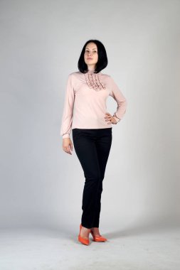 Gri bir arka plan üzerinde poz güzel genç kız