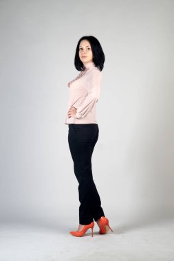 Gri bir arka plan üzerinde poz güzel genç kız