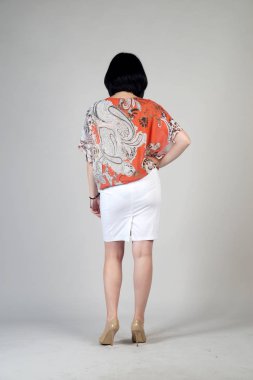 Gri bir arka plan üzerinde poz güzel genç kız