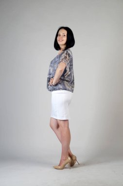 Gri bir arka plan üzerinde poz güzel genç kız