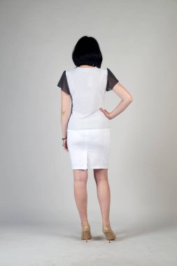 Gri bir arka plan üzerinde poz güzel genç kız