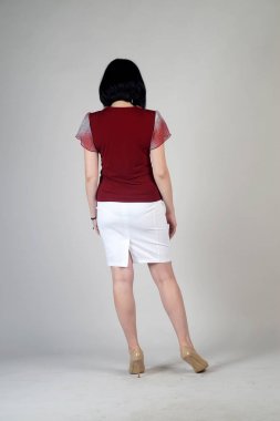 Gri bir arka plan üzerinde poz güzel genç kız