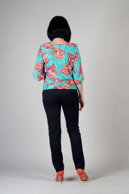 Gri bir arka plan üzerinde poz güzel genç kız