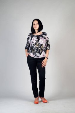 Gri bir arka plan üzerinde poz güzel genç kız