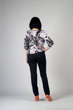 Gri bir arka plan üzerinde poz güzel genç kız