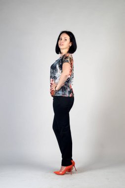 Gri bir arka plan üzerinde poz güzel genç kız