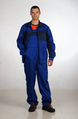 Bir adam tulum ve iş giysisi