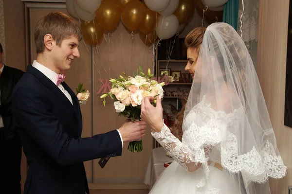 A vőlegény ad egy csokor virágot, hogy menyasszonya — Stock Fotó