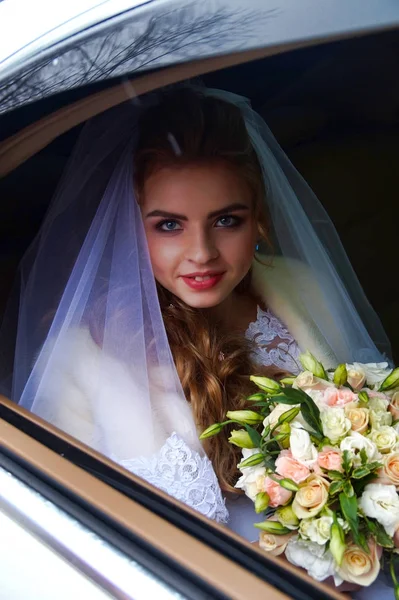 Schöne junge Braut posiert in einem Brautkleid — Stockfoto