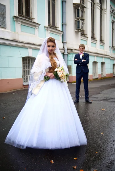 Vackra unga brud poserar i en bröllopsklänning — Stockfoto