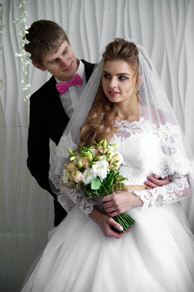 Beautiful young bride and groom posing at studio — Stock Photo, Image