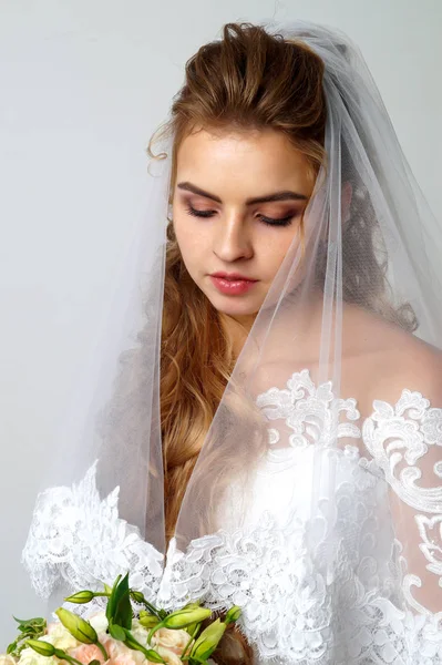 Schöne junge Braut und Bräutigam posiert im Studio — Stockfoto