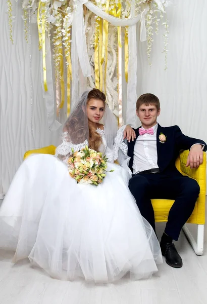 Beautiful young bride and groom posing at studio — Stock Photo, Image